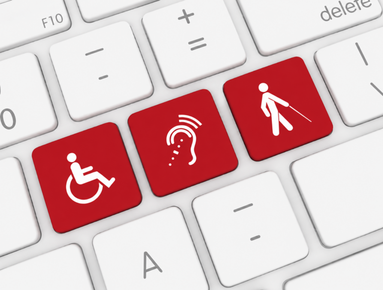 Close-up of a white computer keyboard with three red keys featuring white accessibility symbols for mobility, hearing, and vision disabilities.